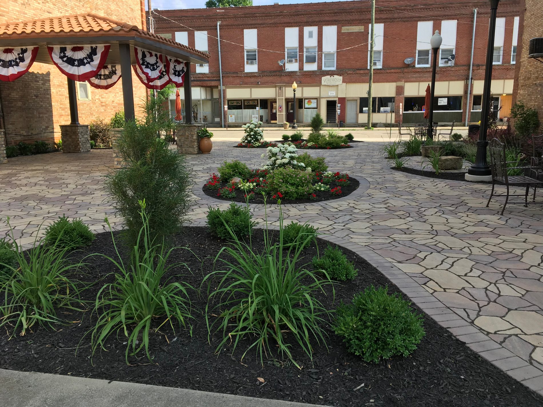 Downtown Bremen, Ohio community plaza with landscaped gardens and patriotic bunting
